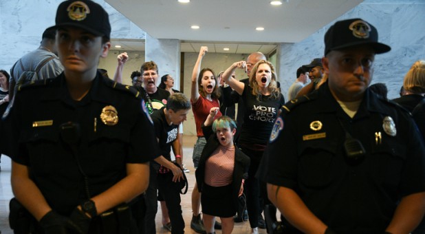 Protesters demonstrate against Judge Brett Kavanaugh's nomination to the U.S. Supreme Court in the atrium of the Hart Senate Office Building.