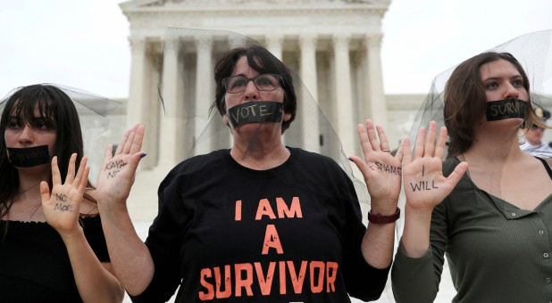 Women stand in silent protest outside the U.S. Supreme Court building after the U.S. Senate voted to confirm the Supreme Court nomination of Judge Brett Kavanaugh on Capitol Hill.