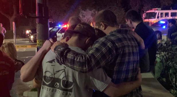 People stand behind cordon tape and hold each other after the shooting in Thousand Oaks, California, U.S., Nov. 8, 2018 in this image obtained from social media.