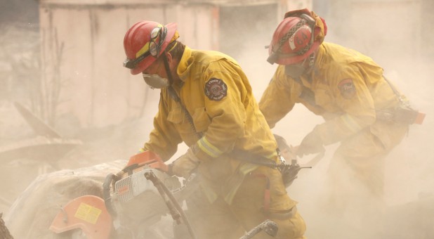 Cal Fire firefighters comb through a house destroyed by the Camp Fire in Paradise, California.
