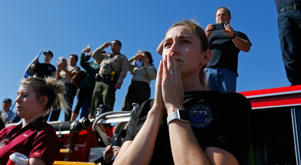 Madison Fuller of Thousand Oaks reacts as she watches from an overpass as a procession for the body of Sergeant Ron Helus, who died in a shooting incident at a Thousand Oaks bar, drives down Ventura HIghway 101 in Thousand Oaks, California.
