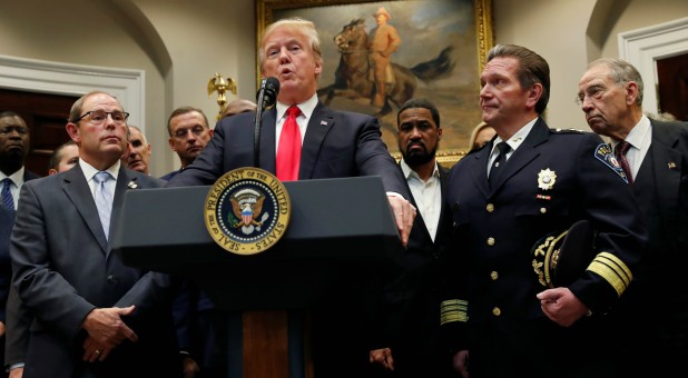 U.S. President Donald Trump, flanked by Chuck Canterbury of the Fraternal Order of Police, and Police Chief Paul Cell of the International Association of Chiefs of Police, speaks about the