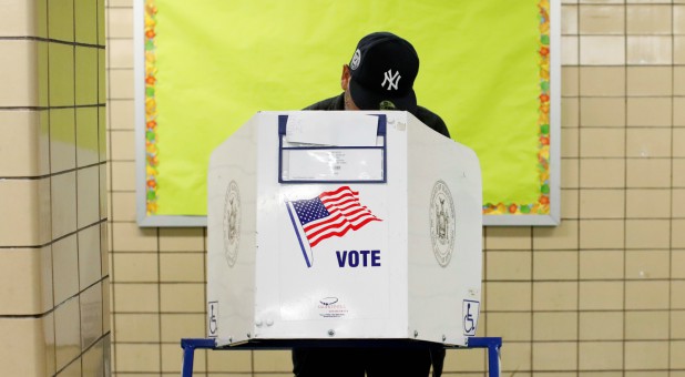 A man wearing a New York Yankees hat votes during the midterm election at P.S. 140 in Manhattan.