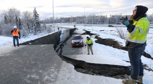 A stranded vehicle lies on a collapsed roadway near the airport after an earthquake in Anchorage, Alaska.