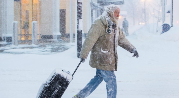 Man moves luggage in snow during a winter storm in Buffalo, New York.