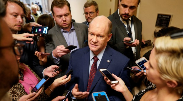 Sen. Chris Coons, D-Delaware, speaks with reporters on the way to the Senate floor on Capitol Hill in Washington.