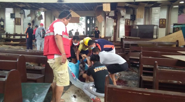 Members of the Philippine Red Cross attend to a casualty inside a church after a bombing attack in Jolo, Philippines.