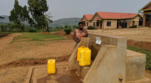 A woman gathers water from a World Vision project in Rwanda.