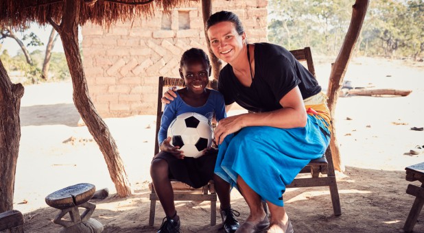Kelly Clark, right, visits with a child in Zambia.