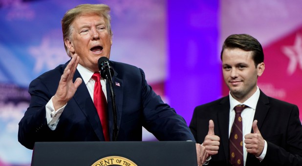 U.S. President Donald Trump speaks as Hayden Williams, member of the Leadership Institute, stands behind him at the Conservative Political Action Conference (CPAC) annual meeting.