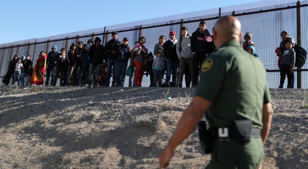A group of Central American migrants surrenders to U.S. Border Patrol Agent Jose Martinez south of the U.S.-Mexico border fence in El Paso, Texas.