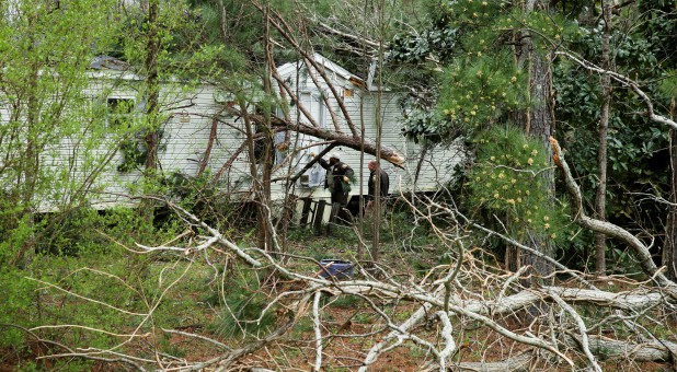 Lee County Sheriff's Deputies knock on the door of a building in order to conduct a welfare check after two back-to-back tornadoes touched down killing at least 23 people, in Beauregard, Alabama.