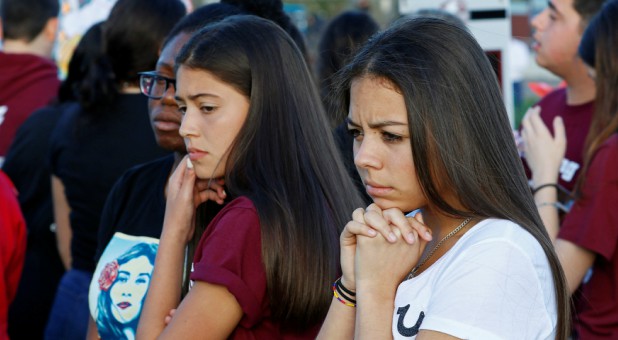 Students view memorials and photos of victims before a memorial service on the one-year anniversary of the shooting that claimed 17 lives at Marjory Stoneman Douglas High School.