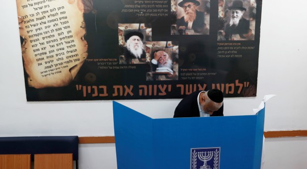 An ultra-Orthodox Jewish stands behind a voting booth as Israelis vote in a parliamentary election, at a polling station in Jerusalem.