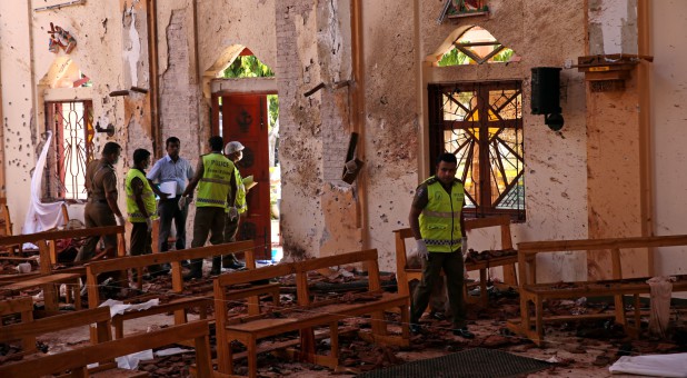 Police officers work at the scene at St. Sebastian Catholic Church, after bomb blasts ripped through churches and luxury hotels on Easter, in Negombo, Sri Lanka.