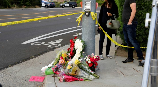 A makeshift memorial is placed by a light pole a block away from a shooting incident where one person was killed at the Congregation Chabad synagogue in Poway, north of San Diego, California.
