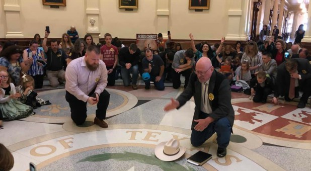 People pray in the Texas State Capitol.