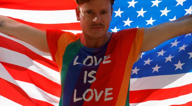 Gilson from Germany poses with an American flag as he participates in the Gay Pride parade along Paulista Avenue in Sao Paulo, Brazil.