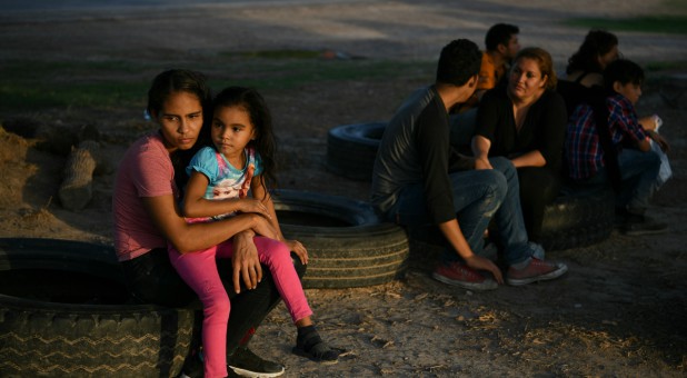 Central American asylum seekers who illegally crossed the Rio Grande nearby wait to be transported to a processing facility after turning themselves in to U.S. Border Patrol in Los Ebanos, Texas.