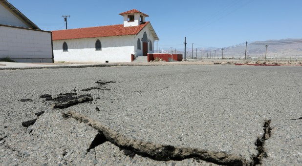 Cracks are seen in the street next to Trona Community Church after a powerful magnitude 7.1 earthquake broke, triggered by a 6.4 the previous day, near the epicenter in Trona.
