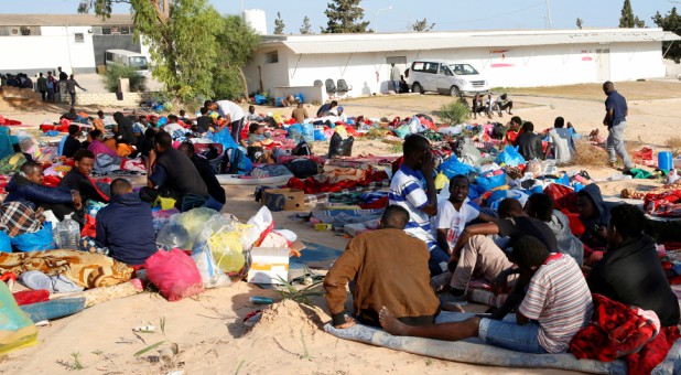 Migrants are seen with their belongings at the yard of a detention center for mainly African migrants, hit by an airstrike, in the Tajoura suburb of Tripoli, Libya.