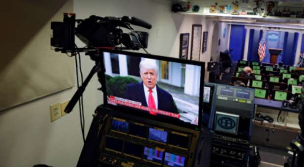 U.S. President Donald Trump is seen making remarks on a television monitor from the White House Briefing Room.
