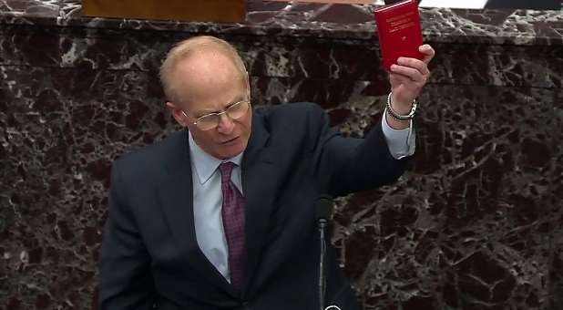 Attorney David Schoen, representing and defending former President Donald Trump, holds up a copy of Quotations by Chairman Mao Tse-Tung as he addresses the U.S. Senate as it begins the second impeachment trial of former president, on charges of inciting the deadly attack on the U.S. Capitol, on the floor of the Senate chamber on Capitol Hill in Washington, U.S., February 9, 2021