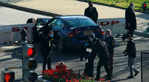 Law enforcement officers hold up a U.S. Capitol Police jacket at the site after a car rammed a police barricade outside the U.S. Capitol building on Capitol Hill in Washington, U.S., April 2, 2021.
