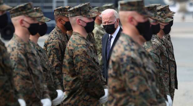 U.S. President Joe Biden looks on as he hands challenge coins to the members of the U.S. Marine Corps Honor Guard before boarding Air Force One at Dover Air Force Base in Dover, Delaware, U.S., August 29, 2021