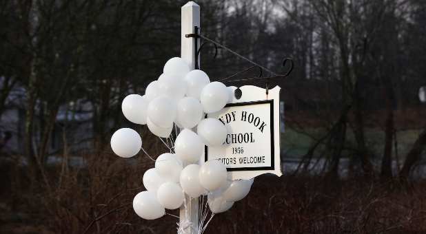 Balloons hang from the Sandy Hook School sign in Sandy Hook, Connecticut December 15, 2012.