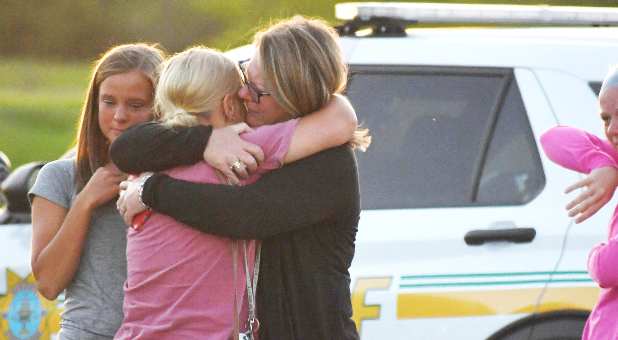 People console each other after a shooting outside Cornerstone Church in Ames, Iowa, U.S. June 2, 2022..