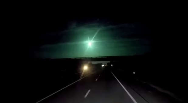 Bright flash from a meteor lighting up the night sky.