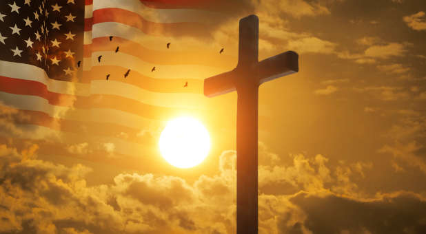 Cross with American flag in the background and rising sun.