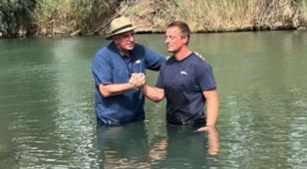 Bear Grylls being baptized in the Jordan River.