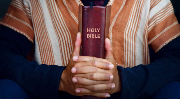 Christian holding a Bible.
