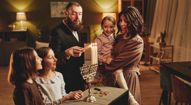 A family lighting the Hanukkah candles.