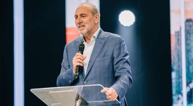 Brian Houston speaking from behind a lectern.