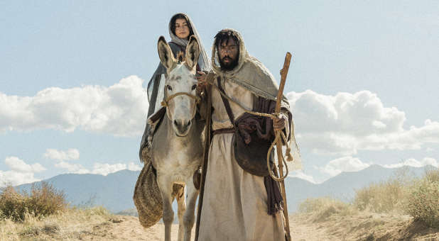 Joseph leading a donkey carrying Mary.