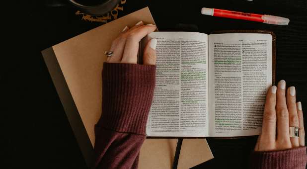 Woman's hands with open Bible and highlighter
