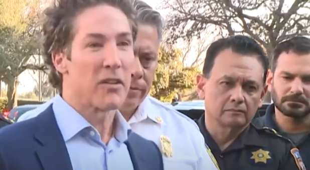Pastor Joel Osteen speaks with reports as law enforcement officials stand by.