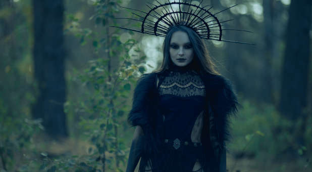 A witch standing in the woods.