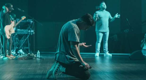 Men prayng in worship team setting.