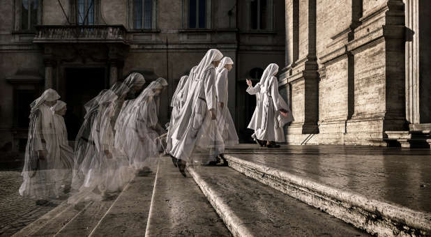 Nun fading away as they walk up steps.