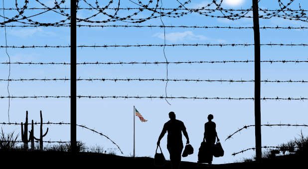 Couple crossing the border into the United States through barbed wire.