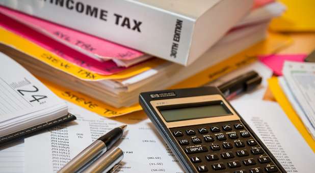 Income tax book and files with calculator and writing implements