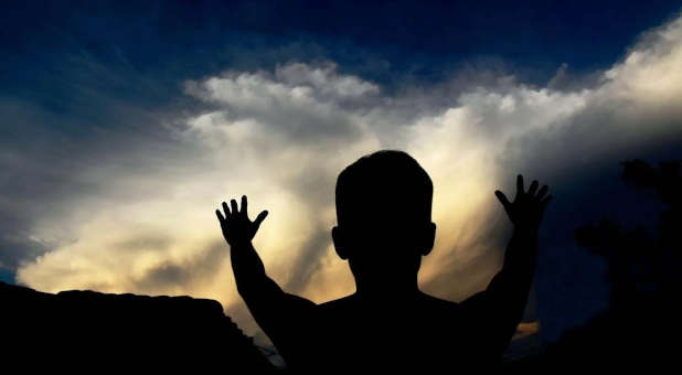 Praising God with clouds in the background.