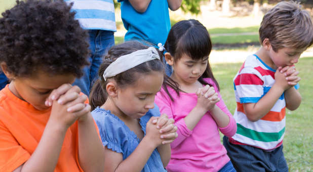Children praying outside.