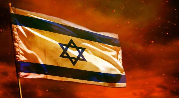 Flag of Israel flying with red sky behind it.